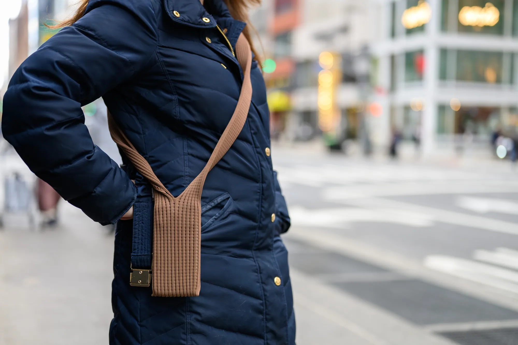 Apple’s iPhone Pocket accessory in a minimal, soft-knit design hanging from a shoulder